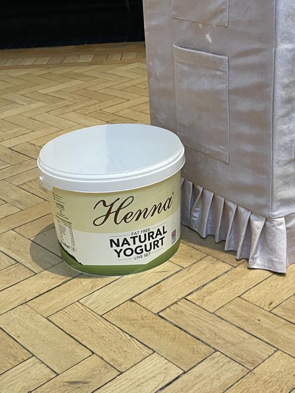 photo of the 10kg Henna yoghurt bucket on the gallery floor. the bucket is white with a beigey pale yellow label
