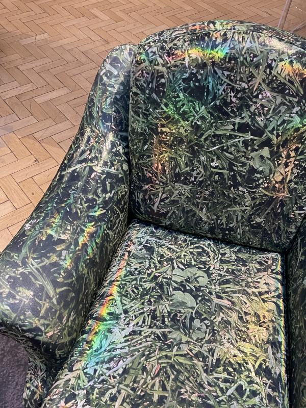 close up of the green armchair, in the holographic salwaar fabric.