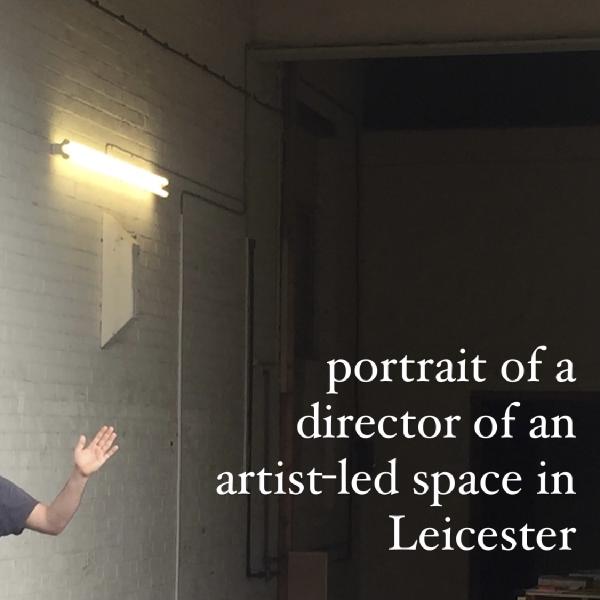 close up of a half empty gallery entrance, a strip light on a wall, a white arm waving, body cropped just out of frame