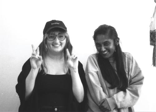 gab and zarina on black and white film smiling, gab wearing a cap with the word butter on it