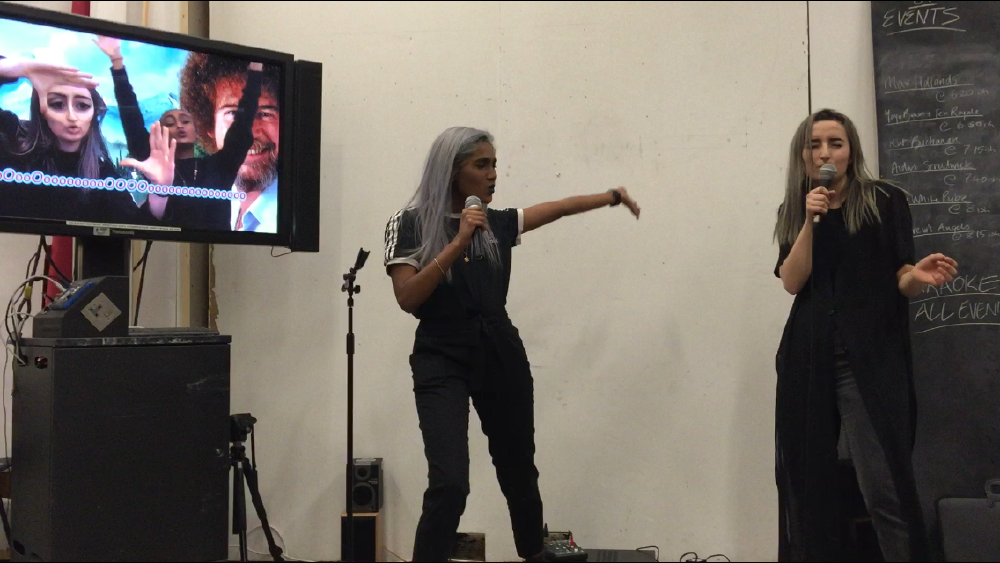 gab and zarina performing karaoke at an open studios at csm after rewriting the words to bohemian rhapsody