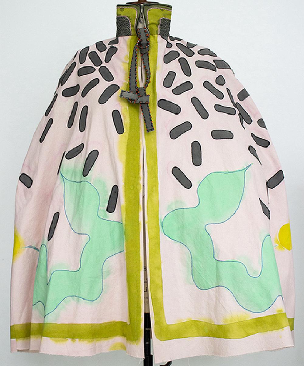 a cape in white fabric with grey rounded rectangle shapes that look like dark confetti over the shoulders and gradually falling down the item of clothing, and two symmetrical green shapes that look like wobbly intestines, and a lime green edge around the split