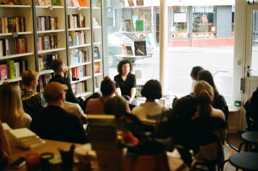 Zarina and Polly Barton at the front of a small crowd in the bookshop mid-event