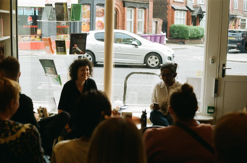 Zarina and Polly Barton at the front of a small crowd in the bookshop mid-event