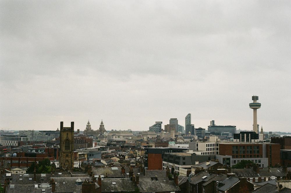 The Liverpool skyline with the liverbirds and Radio City tower visible under a gloomy sky