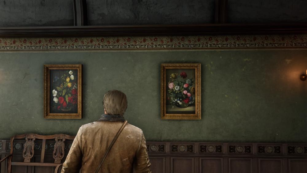 arthur stands looking at two frames images of flowers in vases