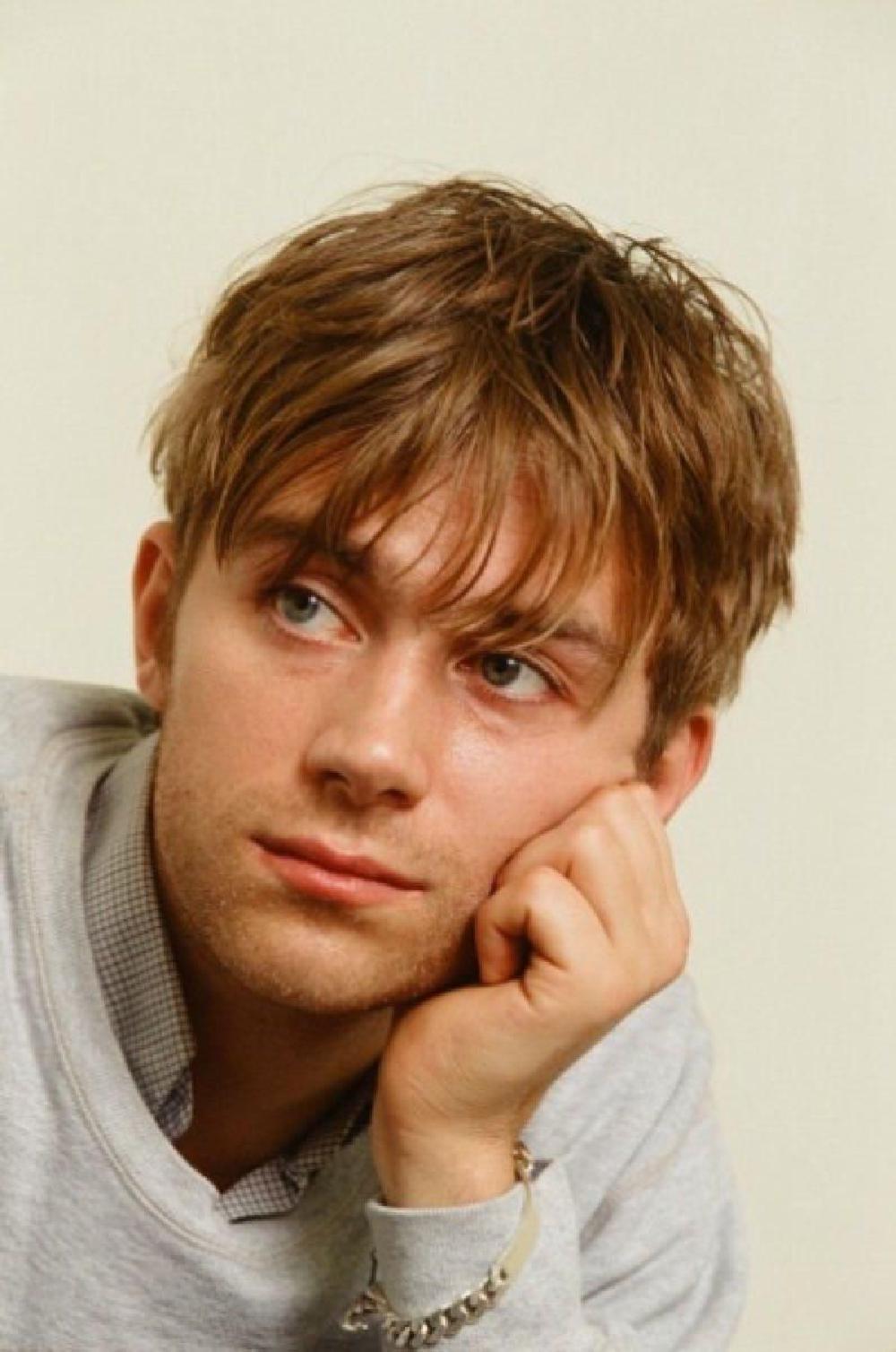 Damon albarn in a shop, in front of the magazine rack, saying: and here you have your culture