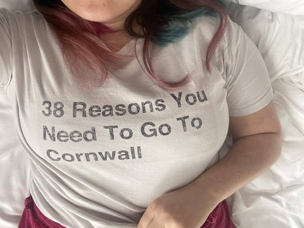 gab takes a selfie focused on her chest showing a white tshirt with the printed words '38 reasons you need to go to cornwall' based on a buzzfeed listicle
