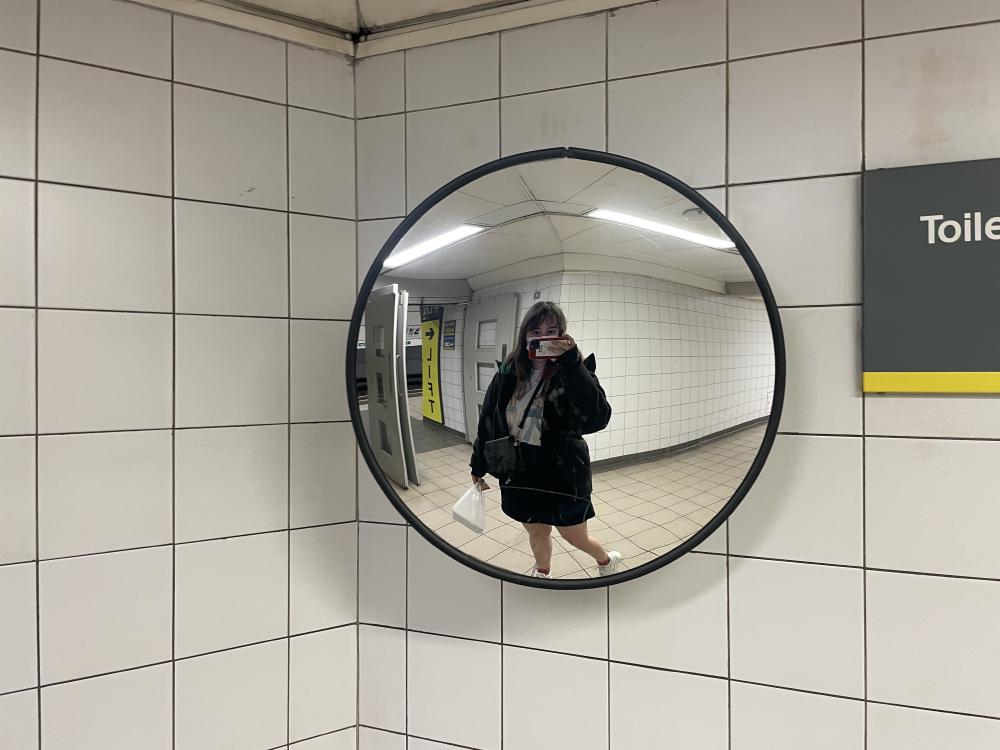 gab on the underground in liverpool taking a picture in a big curved mirror