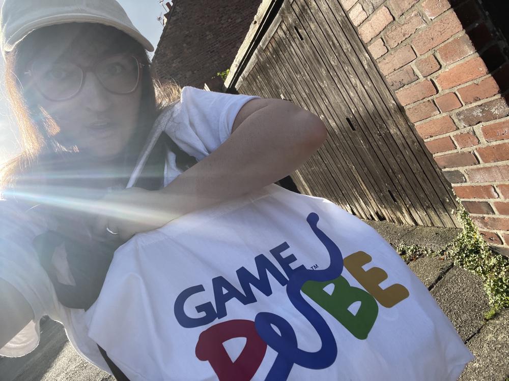 gab holding a huge white tote with the game pube logo on it