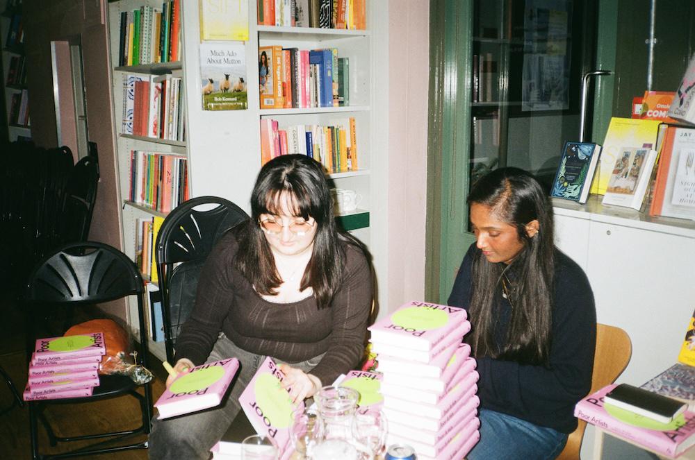 Gab and Zarina signing a pile of books at the London Review Bookshop