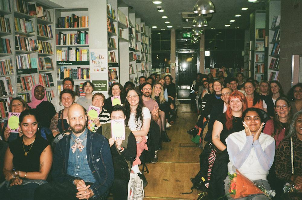 sold out event full of smiley faces at the london review bookshop including a fair amount of people holding the book up