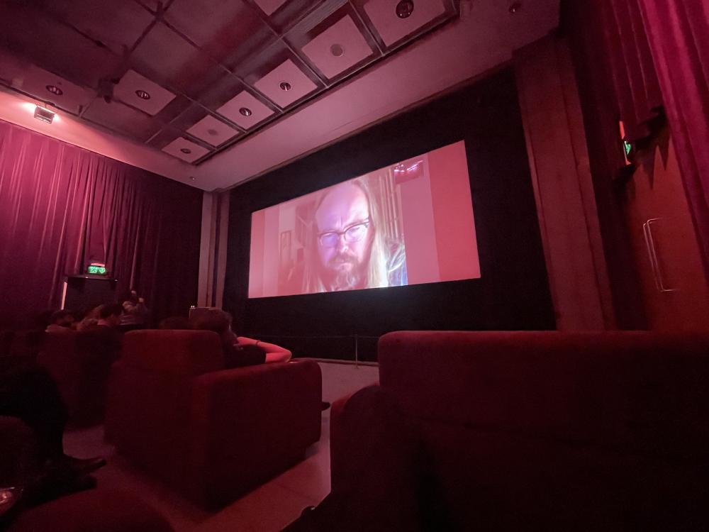richard dawson on zoom during a Q&A in the box at FACT liverpool with big red curtains around the screen