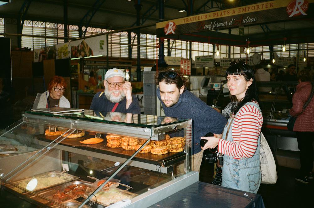 Supermundane Reece and Tahney looking at fish pies at a market in Millau