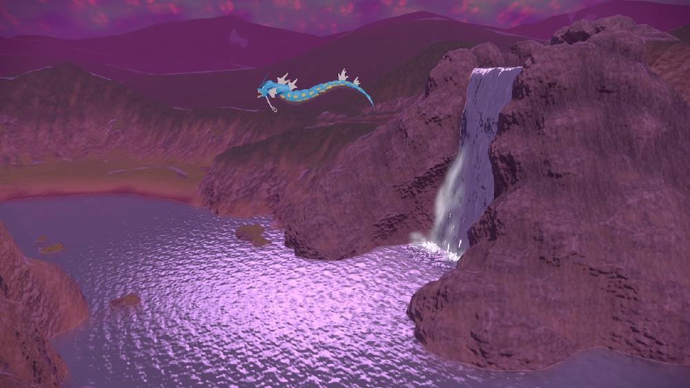 looking out from a cliff, i can see a waterfall spilling onto a lake that is mirroring the moonlight, and overtop there is a Gyarados flying through the air - a blue-dragon looking snake-creature with no wings
