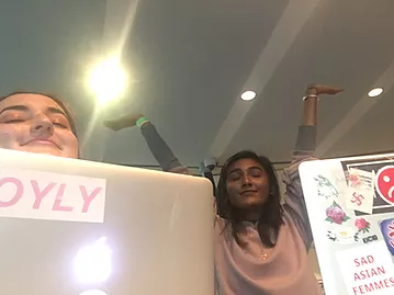 gabrielle and zarina take a selfie with their laptops in front of them