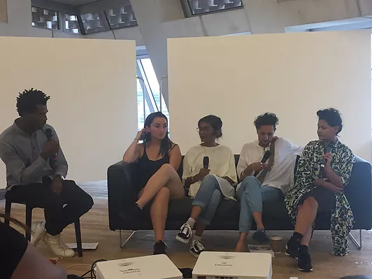 a photo of The white pube next to collective creativity chatting on a couch in a panel talk