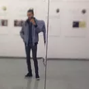 a blurry mirror selfie in a gallery where it&rsquo;s hard to see the person taking the photo