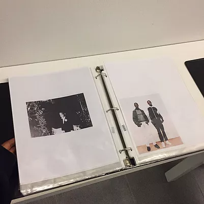 a file on the table with images in plastic wallets that the visitor can flick through
