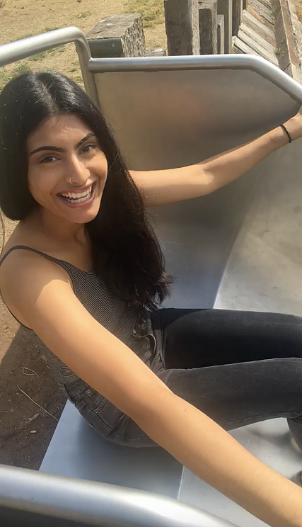 Simran smiles before she heads down a slide