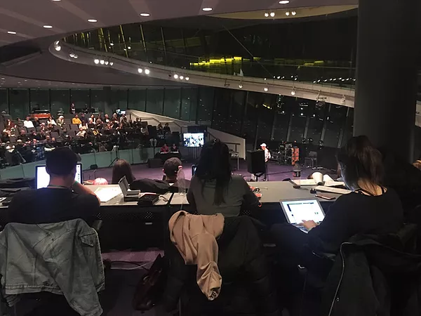 a photo inside the big auditorium of london town hall full of people on laptops