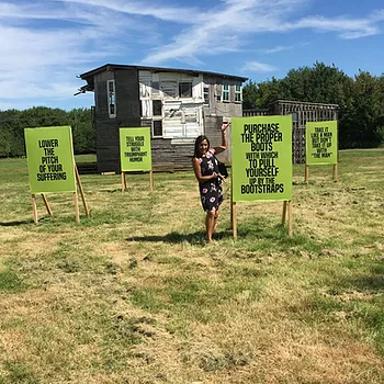 a field has green posters in it with different text, one says lower the pitch of your suffering