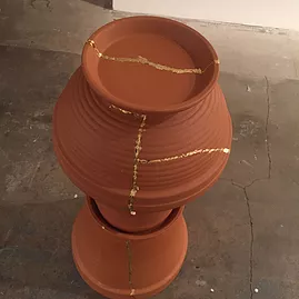 a broken plant pot is glued back together with a material in different colour