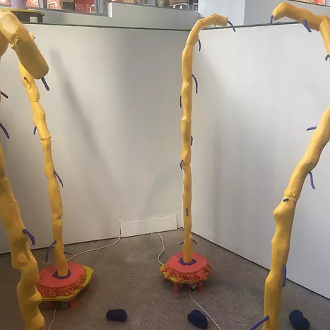 a group of yellow tree like sculptures that just have tiny little hair-like purple pieces coming off them, and they are on discs that if i remember correctly made the yellow stems rotate