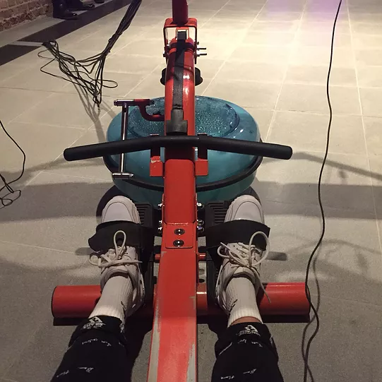 zarina&rsquo;s feet are strapped into the end of a rowing machine