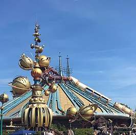 the outside of space mountain which is all gold and astronomical looking, pointing into a dome
