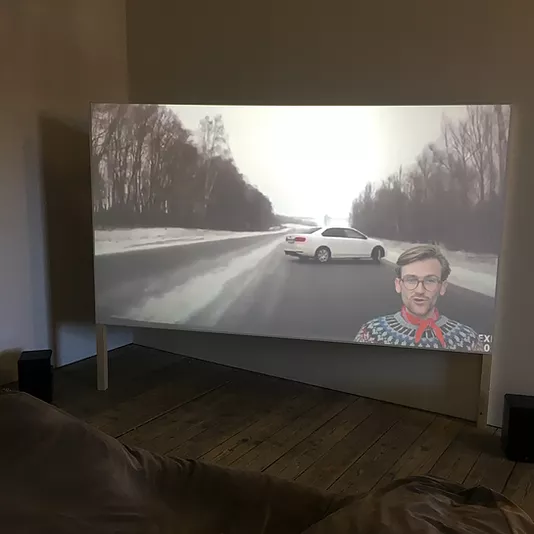 the projection shows a car on a snowy road, and then the artist is 3D screened on front of the footage talking to camera