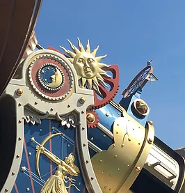 a close up of the outside of space mountain where there is a sun and a moon and a golden archer