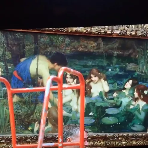 a painting of naked women in a pond full of lily pads with long hair and there is a robed mean leaning into the water, and one of he women at the front has a hand on his arm as if greeting him or bringing him in