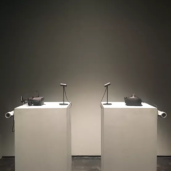 two white plinths opposite each other with a VR headset placed on each one