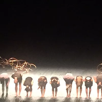 an image of people on stage bowing deeply so everyone is bent over