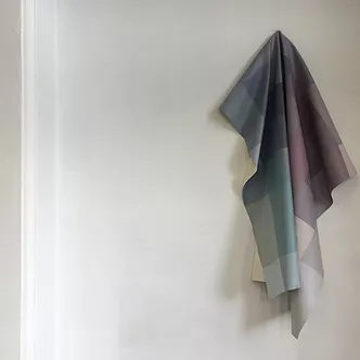 a fabric piece loosely hangs on the wall