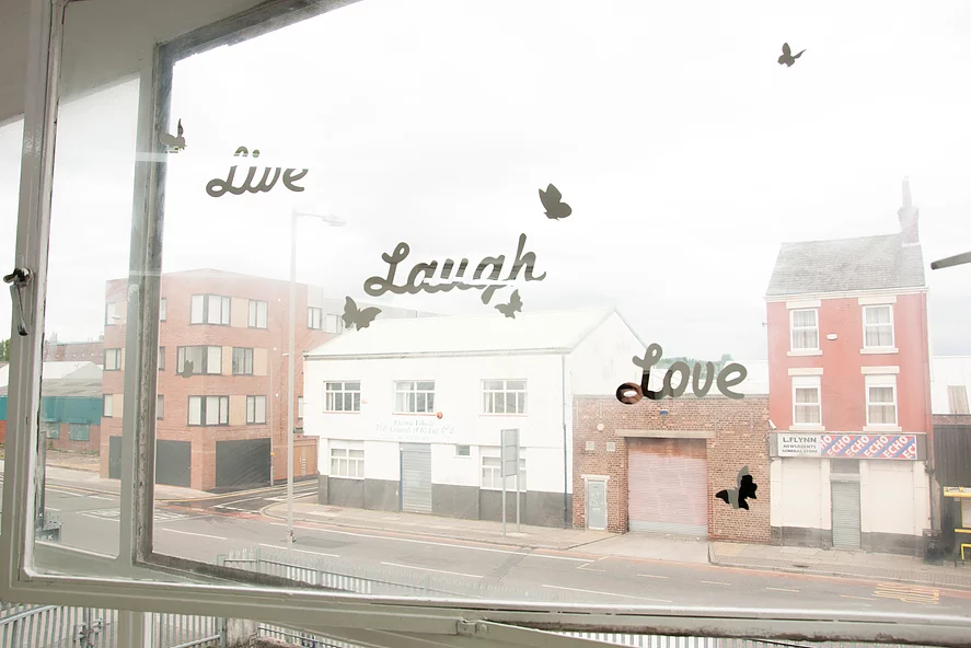 a photo of a window with decals stuck on that say live laugh love in and amongst butterflies