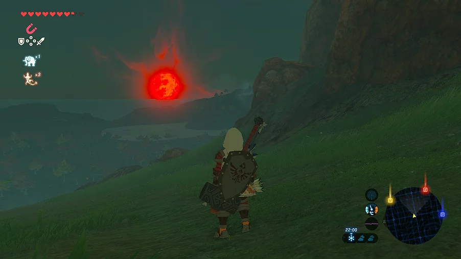 Link wears a hood, shield and hammer on his back, looking out at a nighttime landscape with a burning red moon on the horizon
