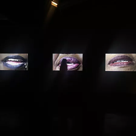 three concurrent videos are playing, all closeups of black women&rsquo;s mouths speaking
