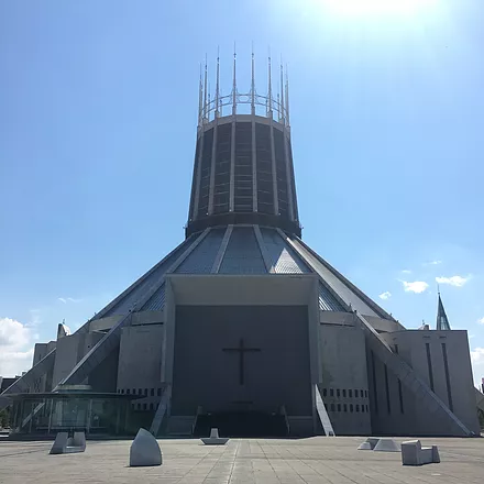 the liverpool metropolitan cathedral with sculptures in a similar grey cement in the courtyard behind it