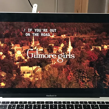 zarina&rsquo;s macbook air is playing the gilmore girls intro which shows an autumnal town and the lyrics if you&rsquo;re out on the road, on the title screen