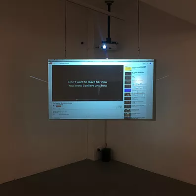 a projection in one corner that has a lyric video on the wall, and the words we can see say &lsquo;don&rsquo;t want to leave her now, you know I believe and how&rsquo;