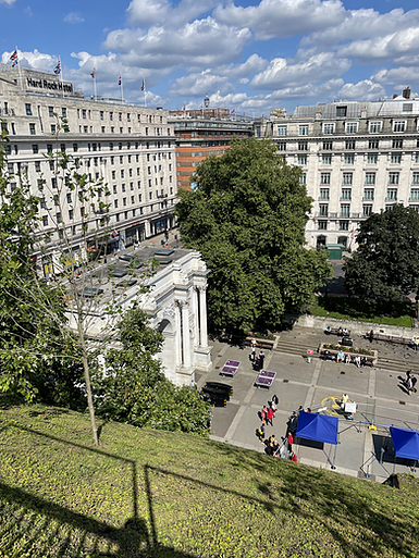 the marble arch is shown from the side, disappearing between trees and other buildings