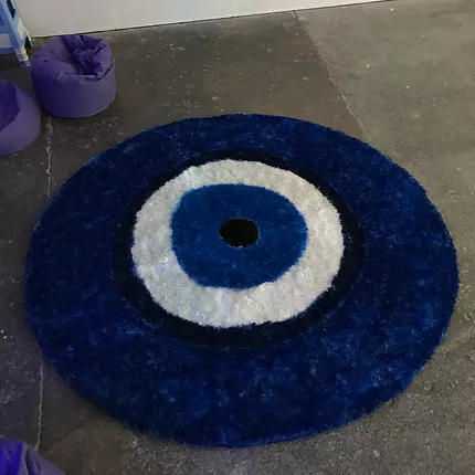 a small round rug designed like an evil eye is there on the floor