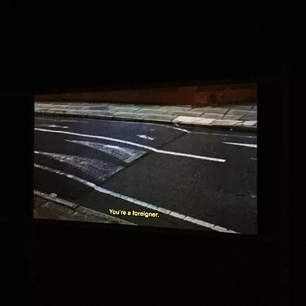 projection of a road with the caption &lsquo;you&rsquo;re a foreigner&rsquo;