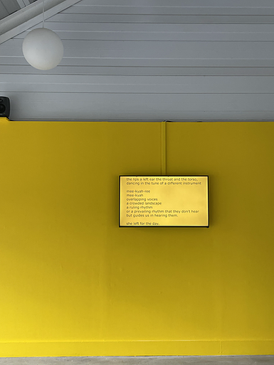 a yellow painted wall with a flat screen tv showing the same yellow with text on screen