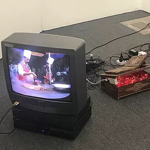 a CRT on the floor shows two chefs on screen