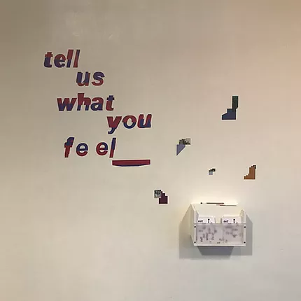 a comment box on the wall matches the exhibition branding, asking &lsquo;tell us what you feel&rsquo;