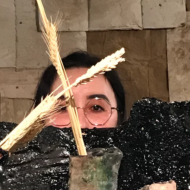 Gab&rsquo;s head pokes up behind one of the sculptures where two pieces of wheat cross 