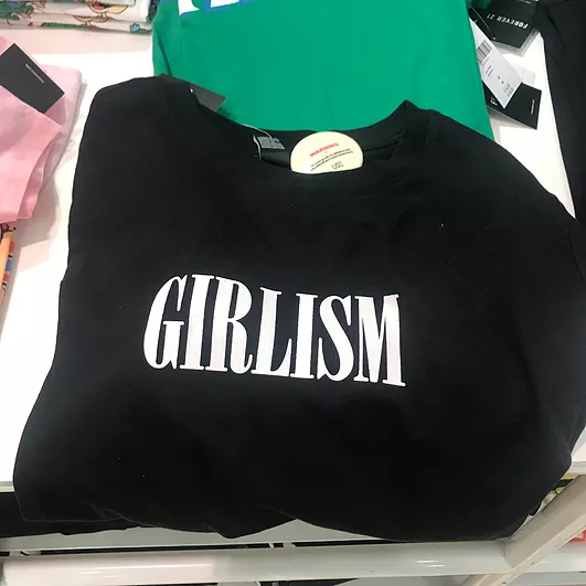 a black tshirt with the white word GIRLISM on it